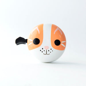 A white bicycle bell with a cute hand-painted cat face design in orange and black and pink.  Suitable for bikes and scooters
