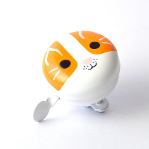 A cute cat-themed bicycle bell with a white and orange cat face design, featuring black eyes, whiskers, and a small pink nose, with a white heart-shaped paw pusher on the side.
