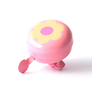 A pink bicycle bell with a yellow flower design on the front, featuring a pink center and a pink handlebar clip, shown on a white background.