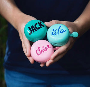 Beep personalised name bells with names handprinted with cool fonts onto tops of green, pink and mint bike bells