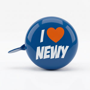 A blue bicycle bell with a metal lever, featuring a graphic that reads 'I [red heart] NEWY' in white text, set against a plain white background.